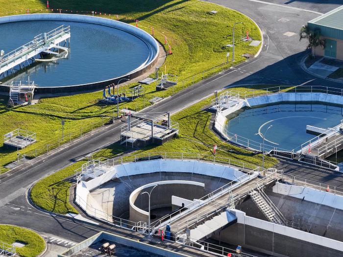 Circular clarifier tanks at a wastewater treatment plant, seen from above.